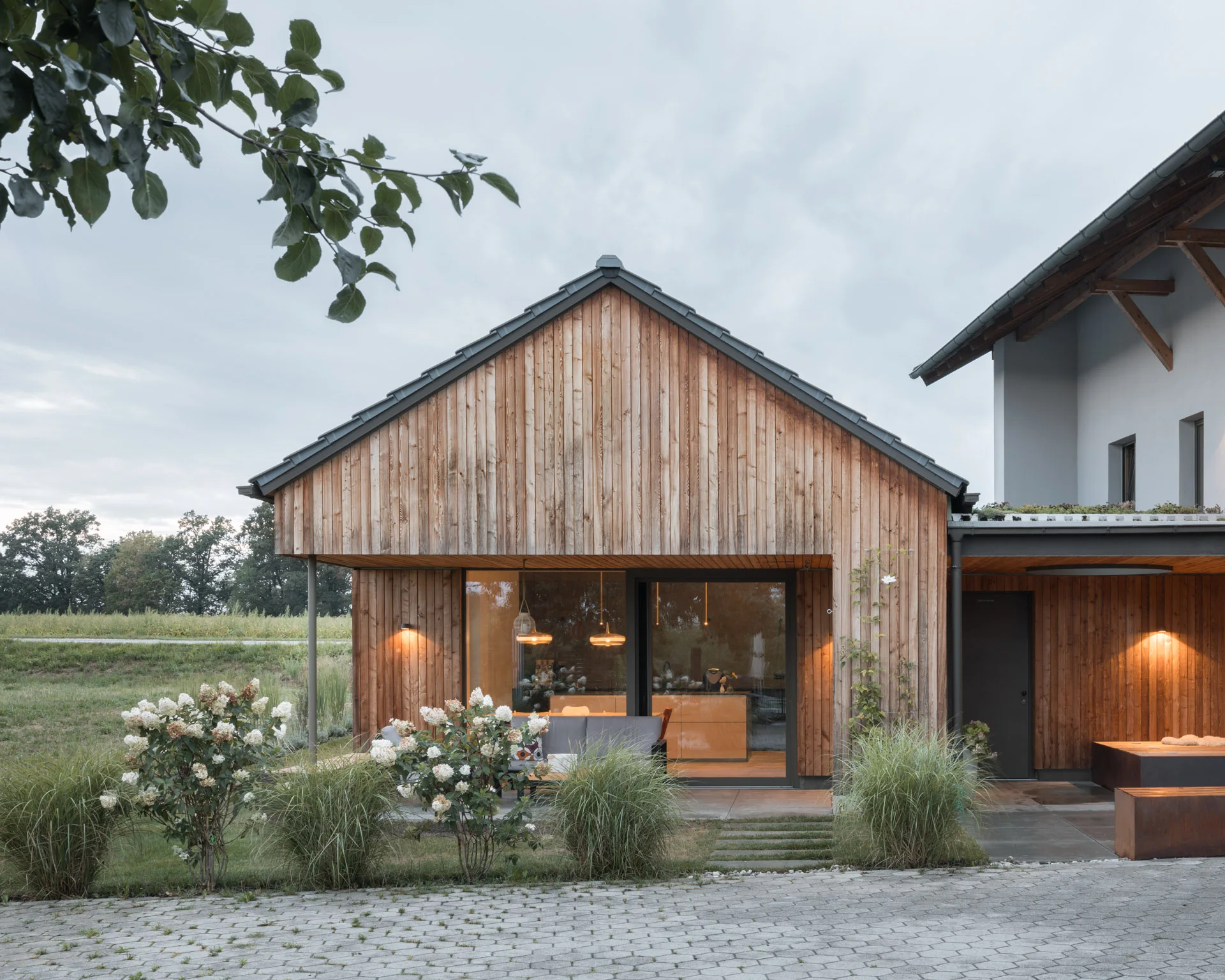 Gartenansicht des Wohnhauses mit Holzfassade und Terrasse