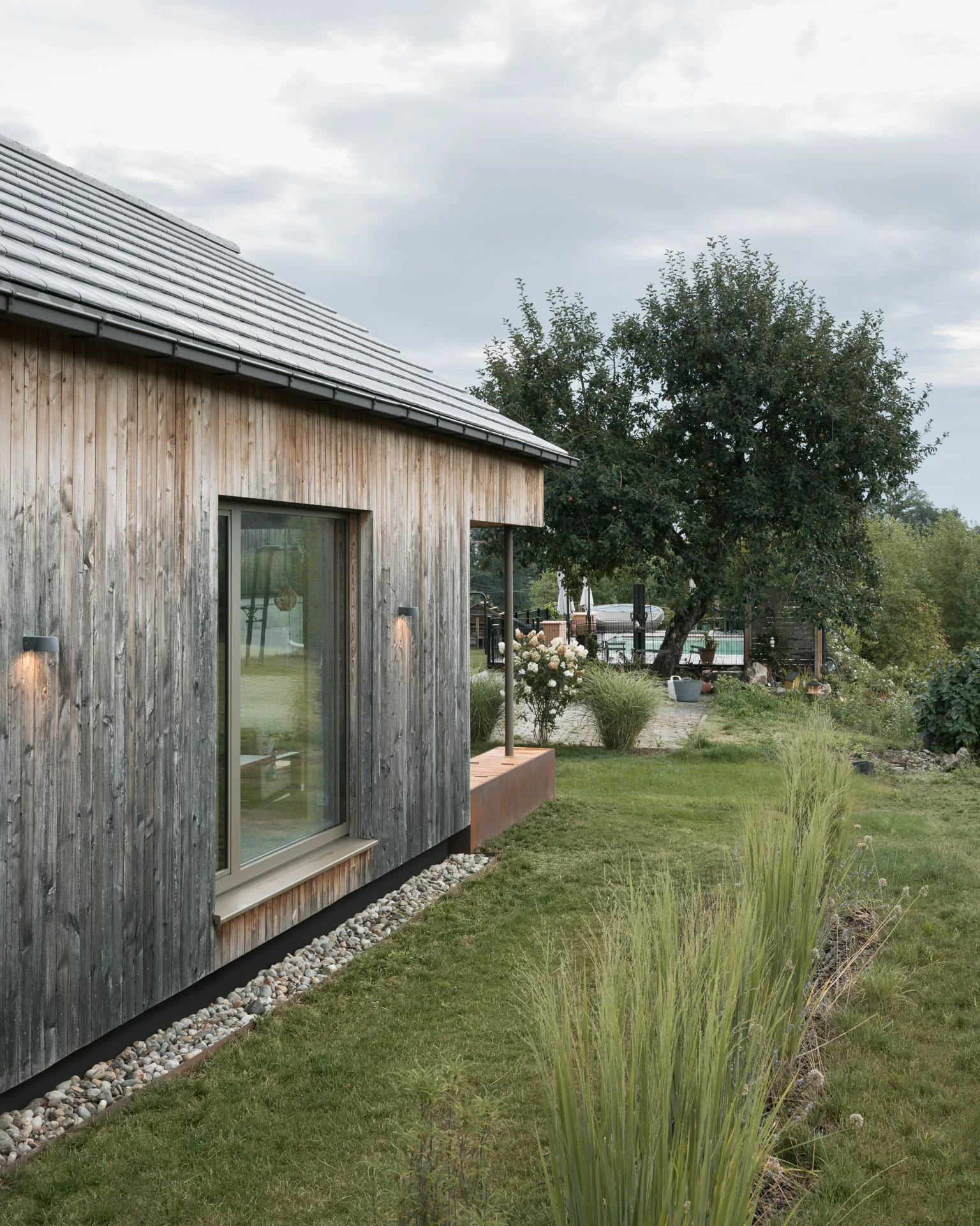 Giebelseite mit Holzschalung und Blick in die Wiese