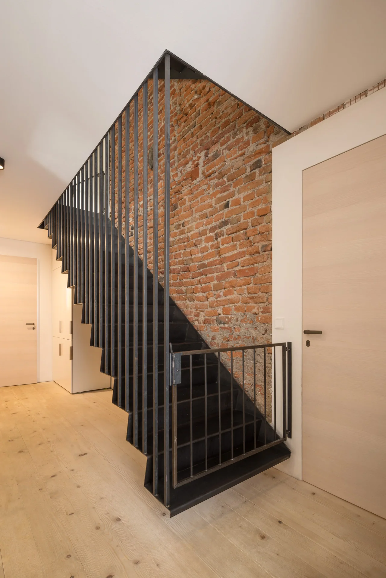 Treppe mit Stahlgeländer und Ziegelwand