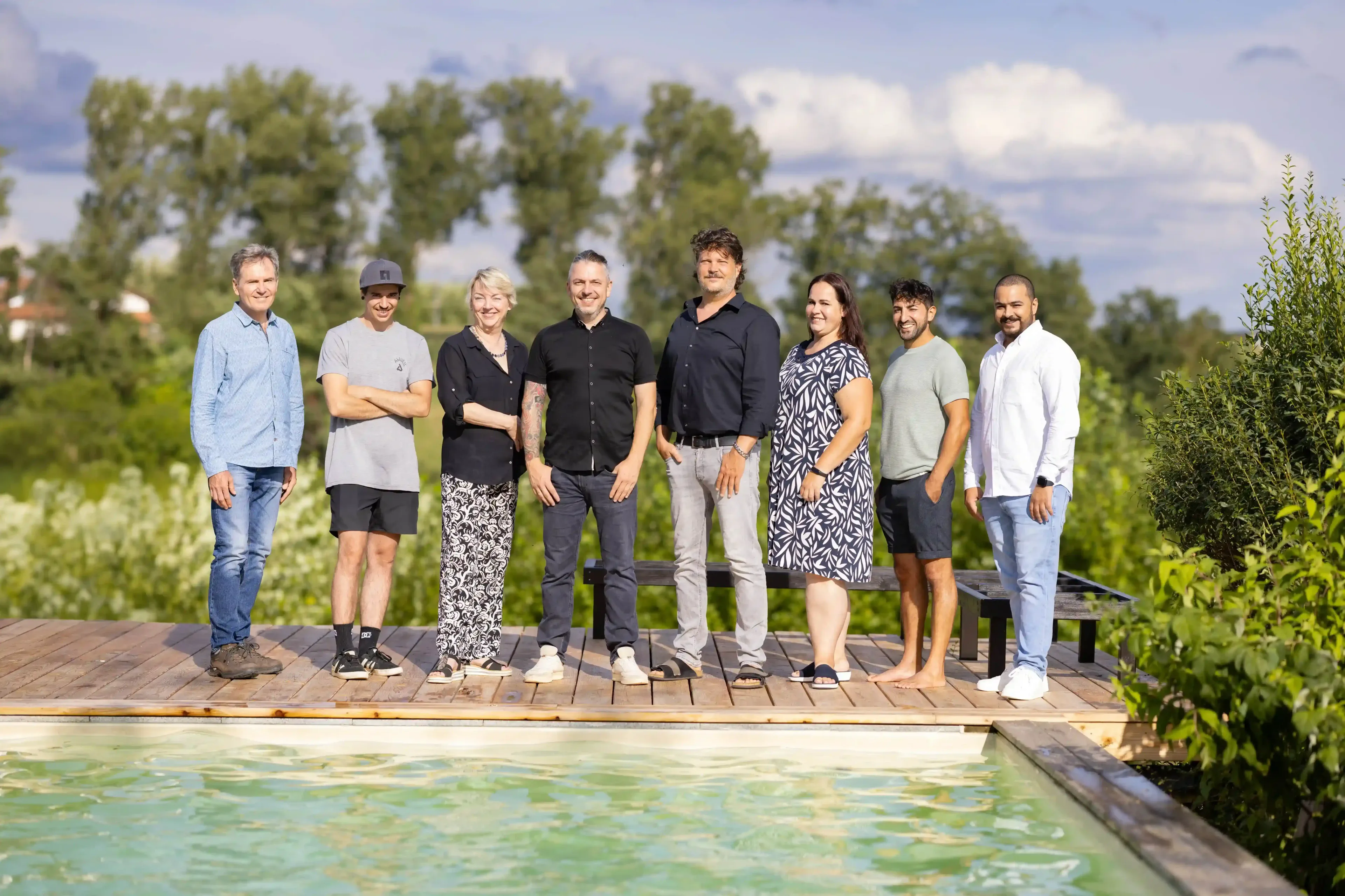 Das Team von Ackermann Architekten auf einem Holzsteg am Naturpool